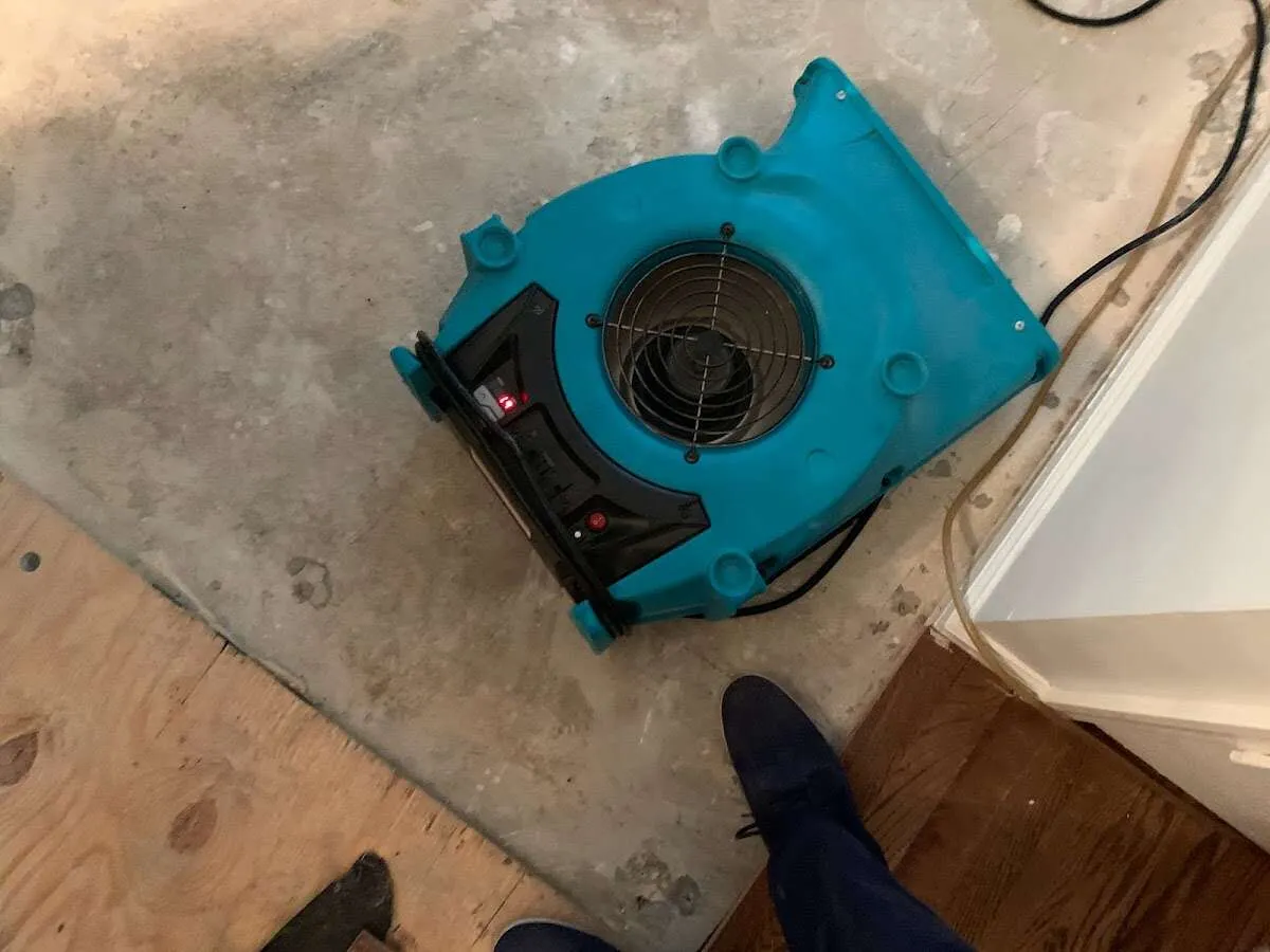 Air mover drying subfloor during Commercial Water Damage Restoration in East Brunswick